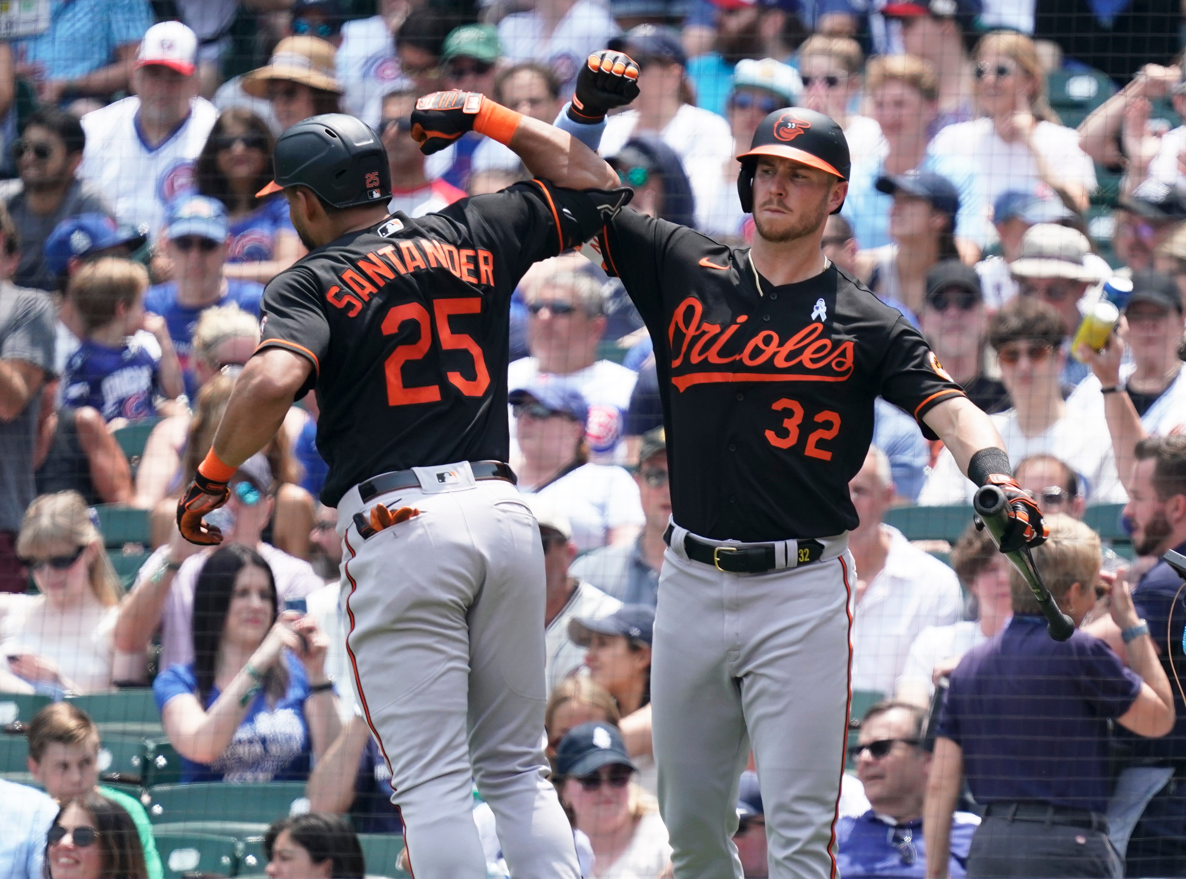 Anthony Santander #25 of the Baltimore Orioles is congratulated by Ryan O'Hearn #32 of the Baltimore Orioles following a home run during the fourth inning of a game against the Chicago Cubs at Wrigley Field on June 18, 2023 in Chicago, Illinois.