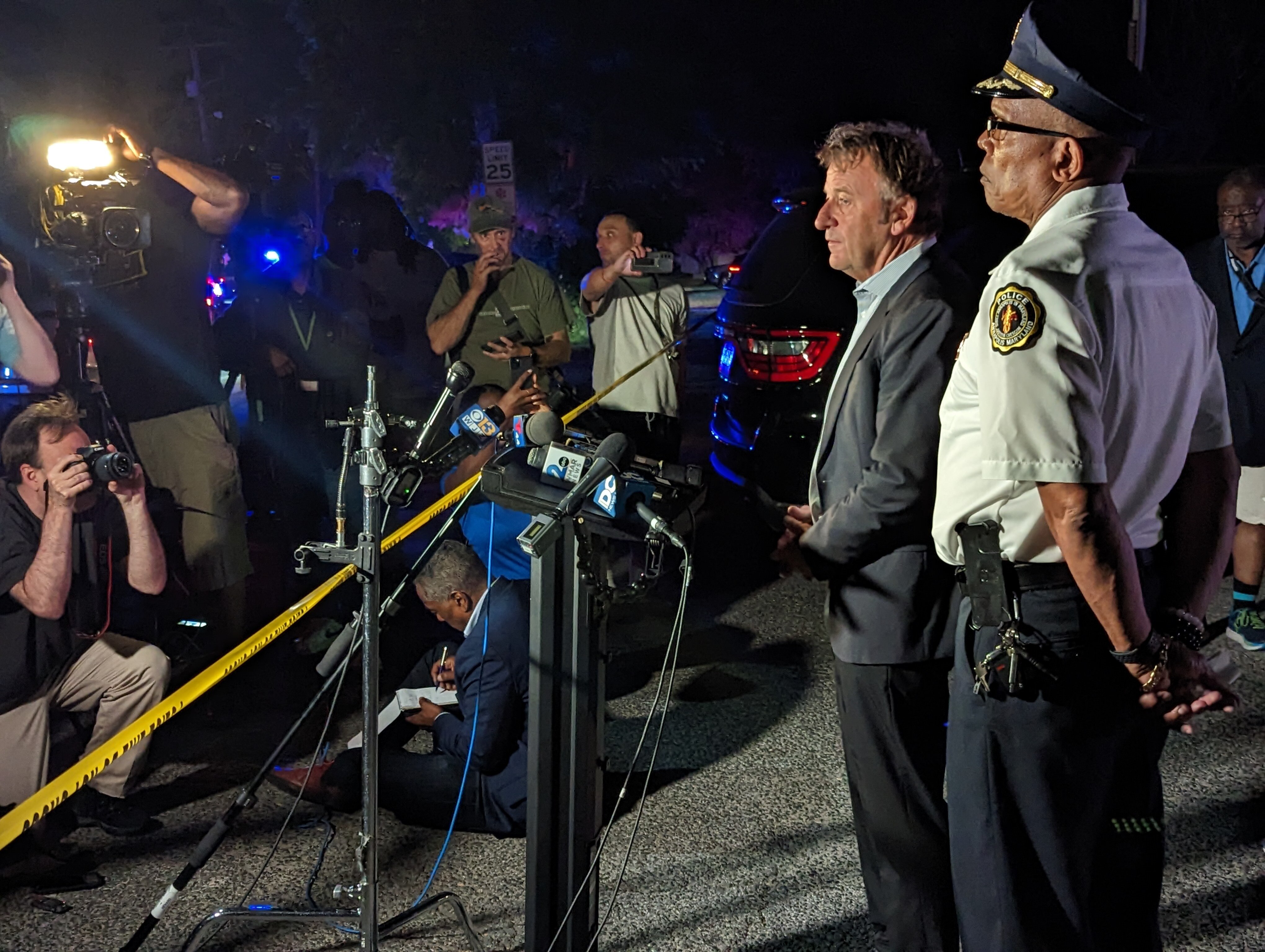 Annapolis Mayor Gavin Buckley, center, talks to the news media as Police Chief ed Jackson listens after a triple homicide Sunday, June 11