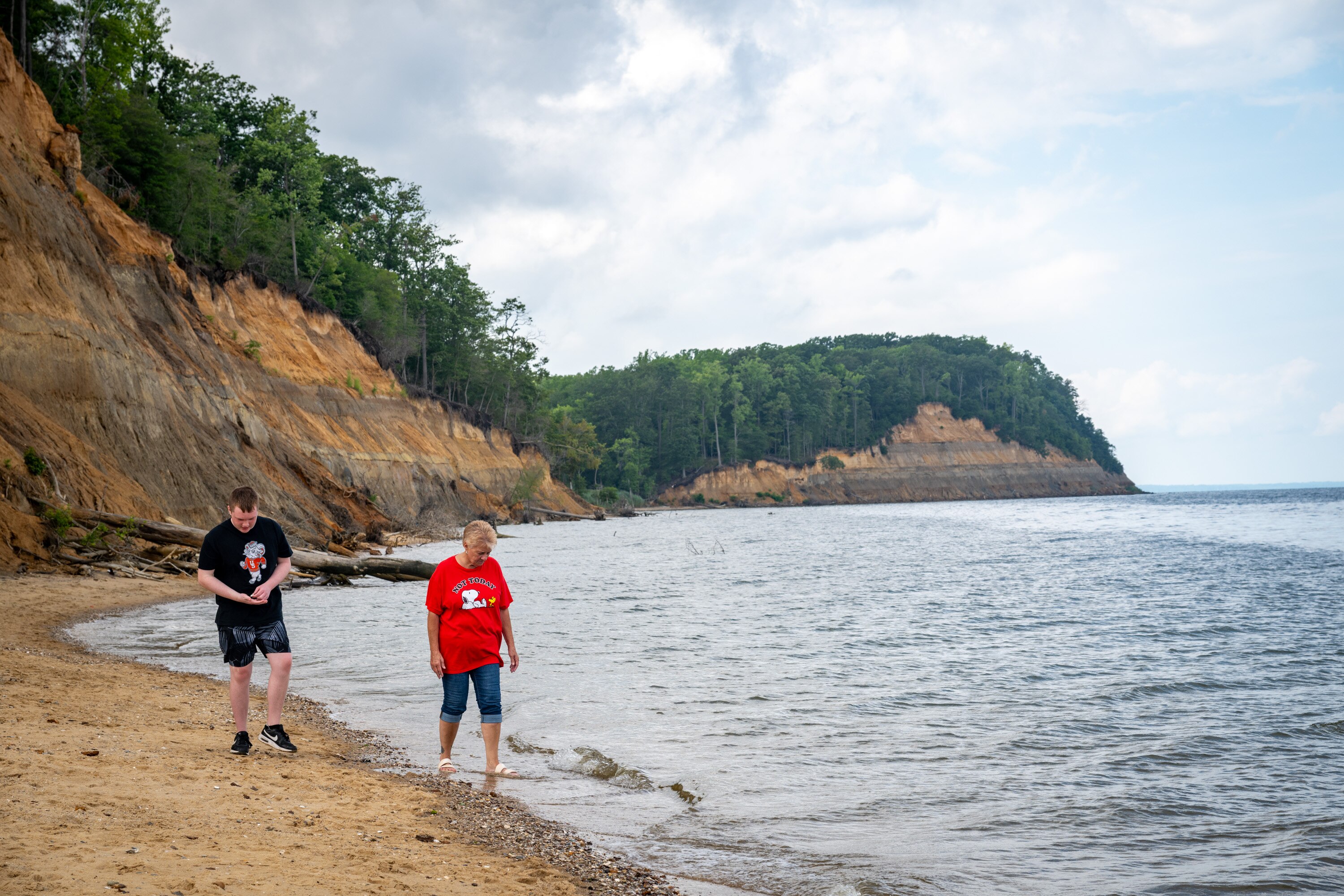 Tuesday, July 15, 2025 — Hayden Adams, 14, walks along the beach at Calvert Cliffs State Park with his grandmother. They were visiting from central Ohio.