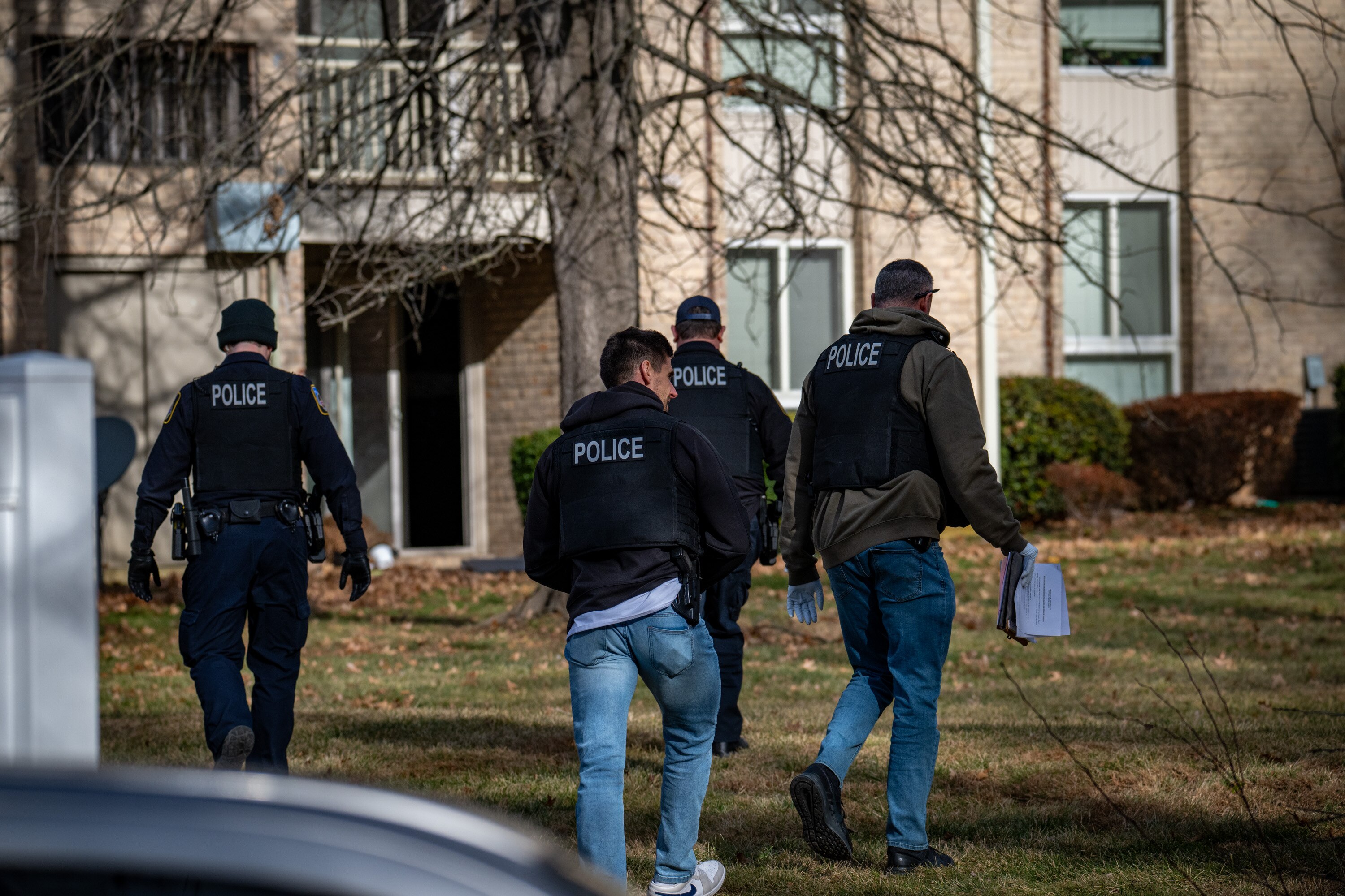 Baltimore County police walk behind an apartment building on Spring Head Court in Cockeysville while investigating reports of gunfire. 