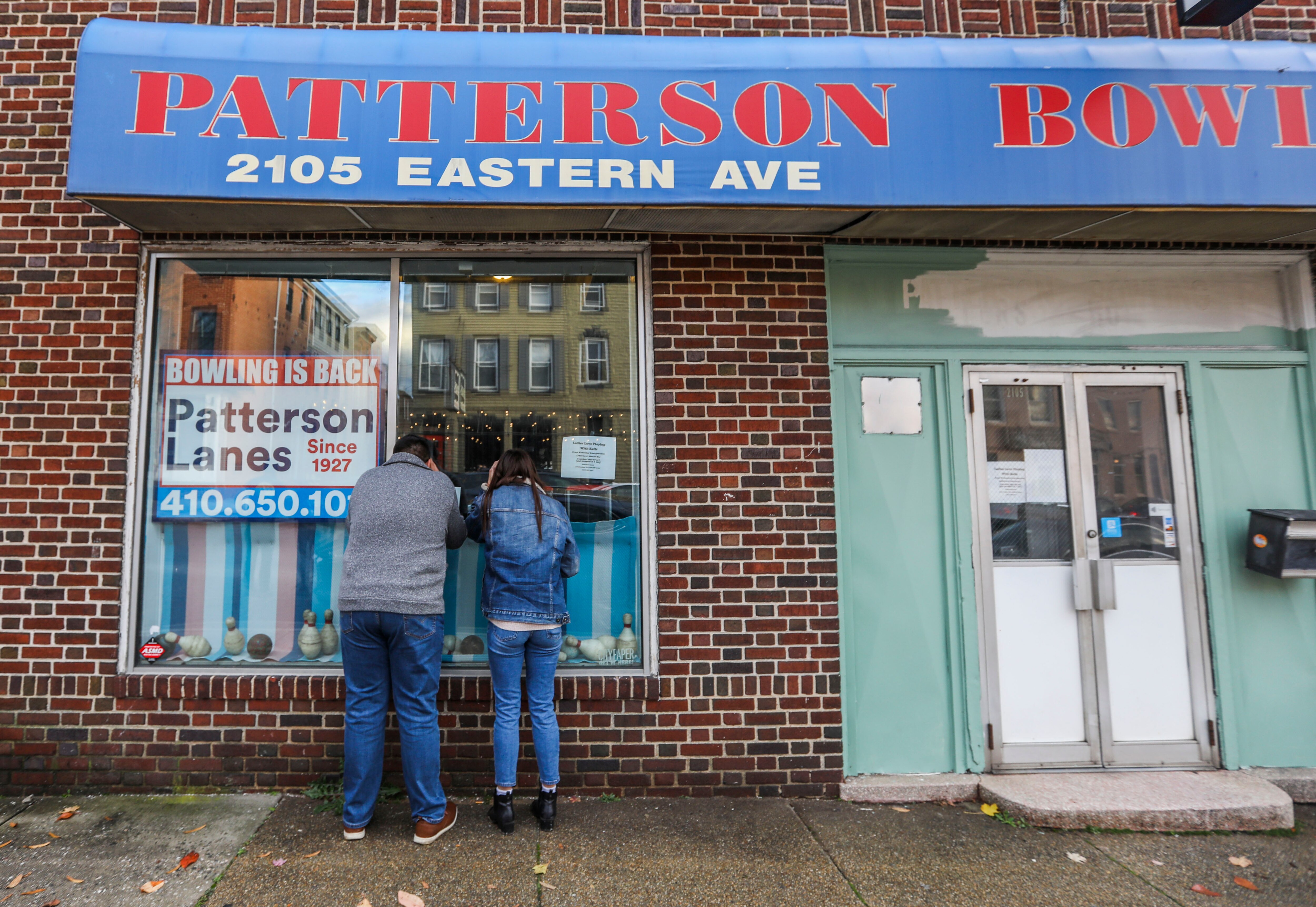 Brandon Torrento and Suzanne Sauter peer into the windows of Patterson Bowling Center after showing up and realizing the doors were locked and the lights were off.