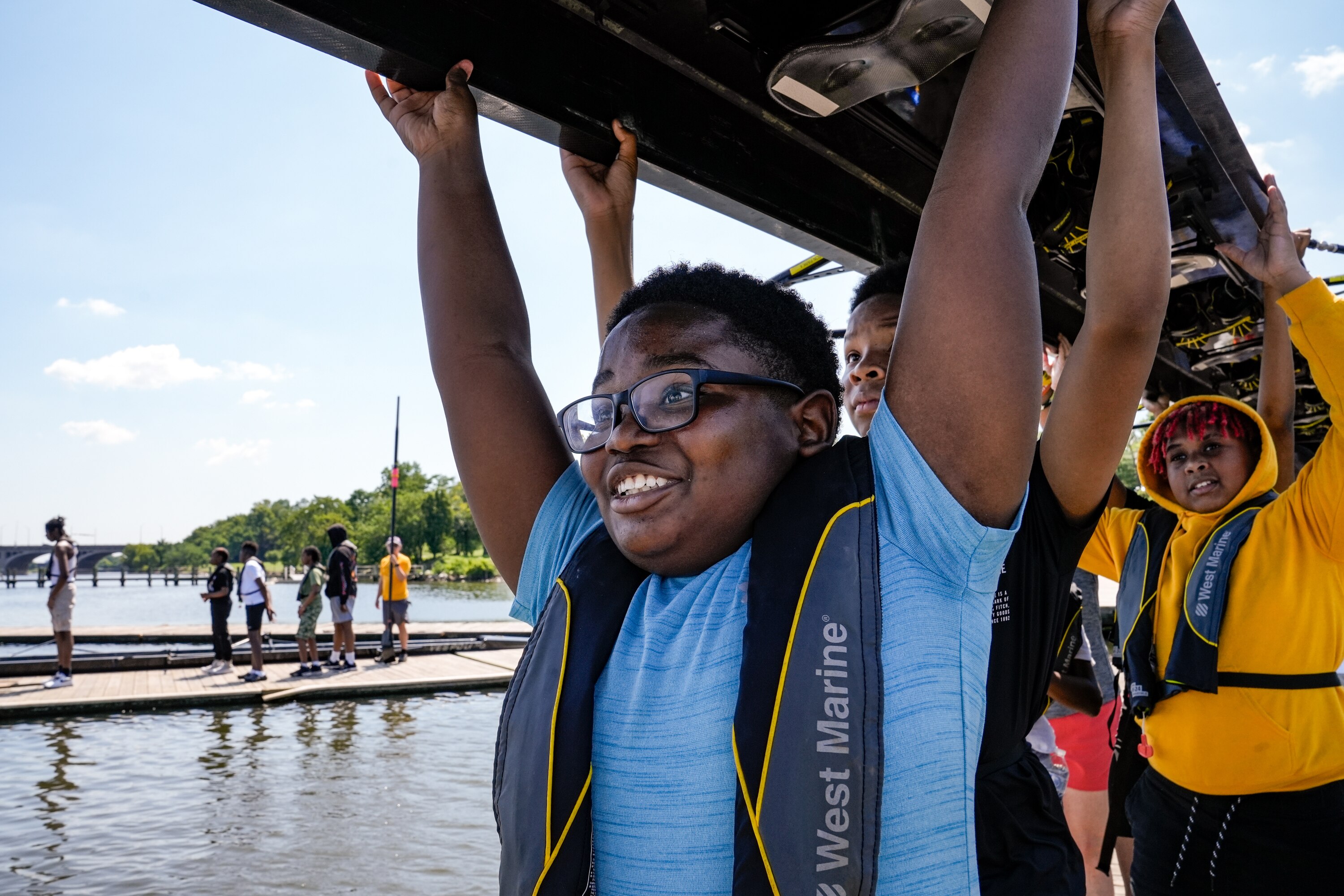 Cordell Pinckney Jr. leads the way carrying the boat out to the water on July 11, 2023.