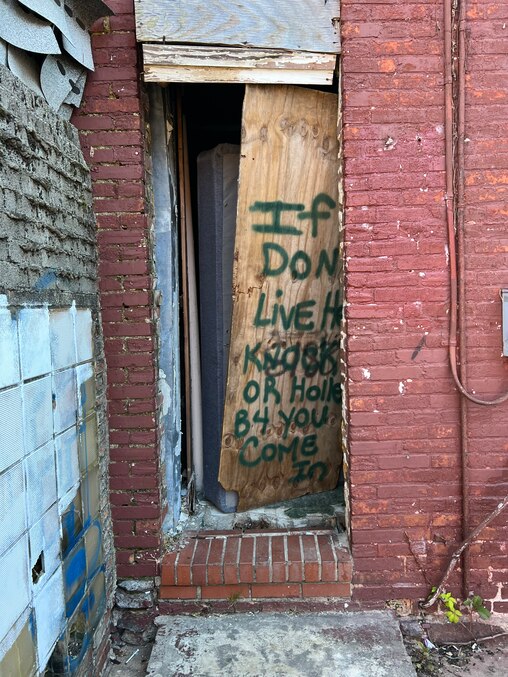 A board propped up in the rear of a Carrollton Ridge home owned by an ABC Capital investor warns visitors to announce their presence.