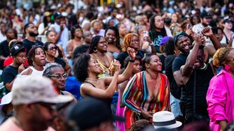 People dance and smile in the packed crowd.