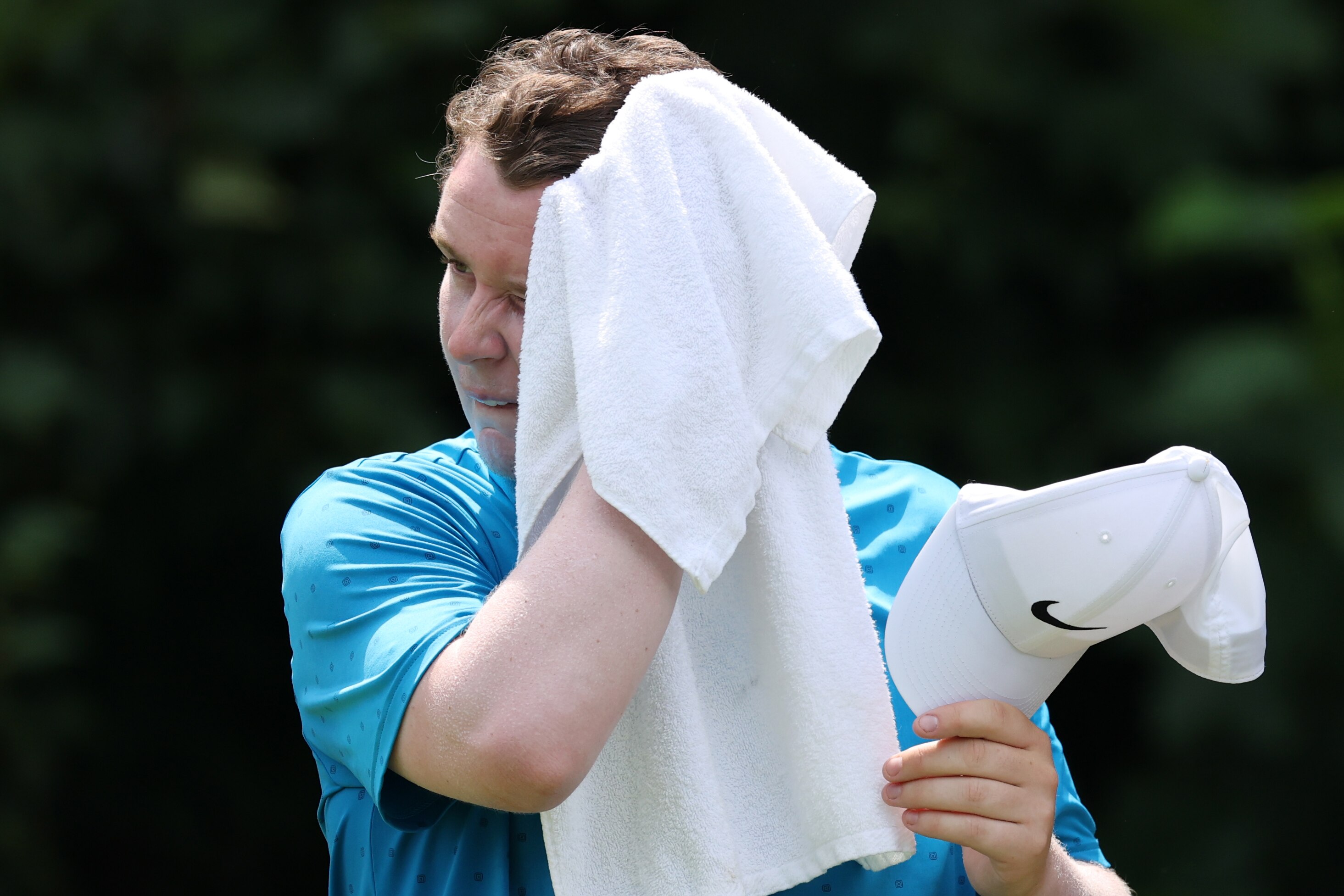 Tournament leader Robert MacIntyre of Scotland towels off on the eighth tee Friday at Caves Valley.