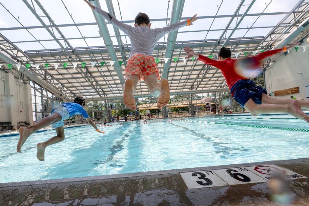 Children jump into the pool at Roger Carter Community Center Pool in Howard County on August 4th, 2025 in Ellicott City, MD.