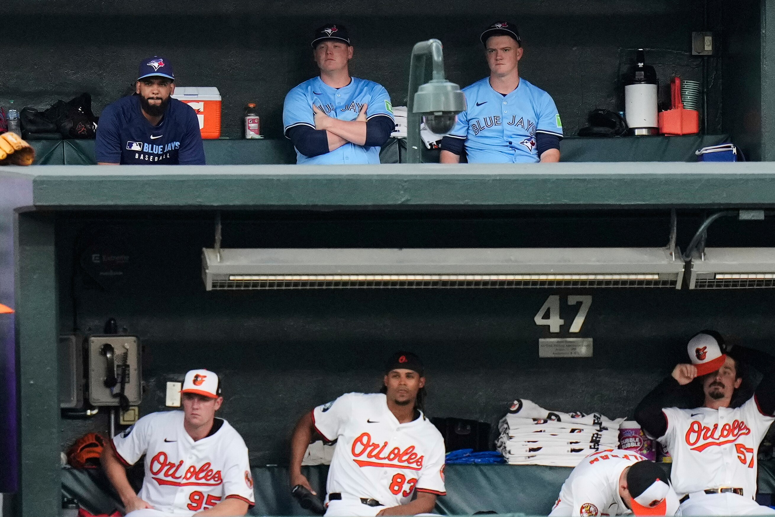 Toronto Blue Jays relief pitcher Seranthony Dominguez, top left, sits in the bullpen above his former teammates shortly after being traded, during the fourth inning in the second baseball game of a doubleheader against the Baltimore Orioles, Tuesday, July 29, 2025, in Baltimore. (AP Photo/Stephanie Scarbrough)