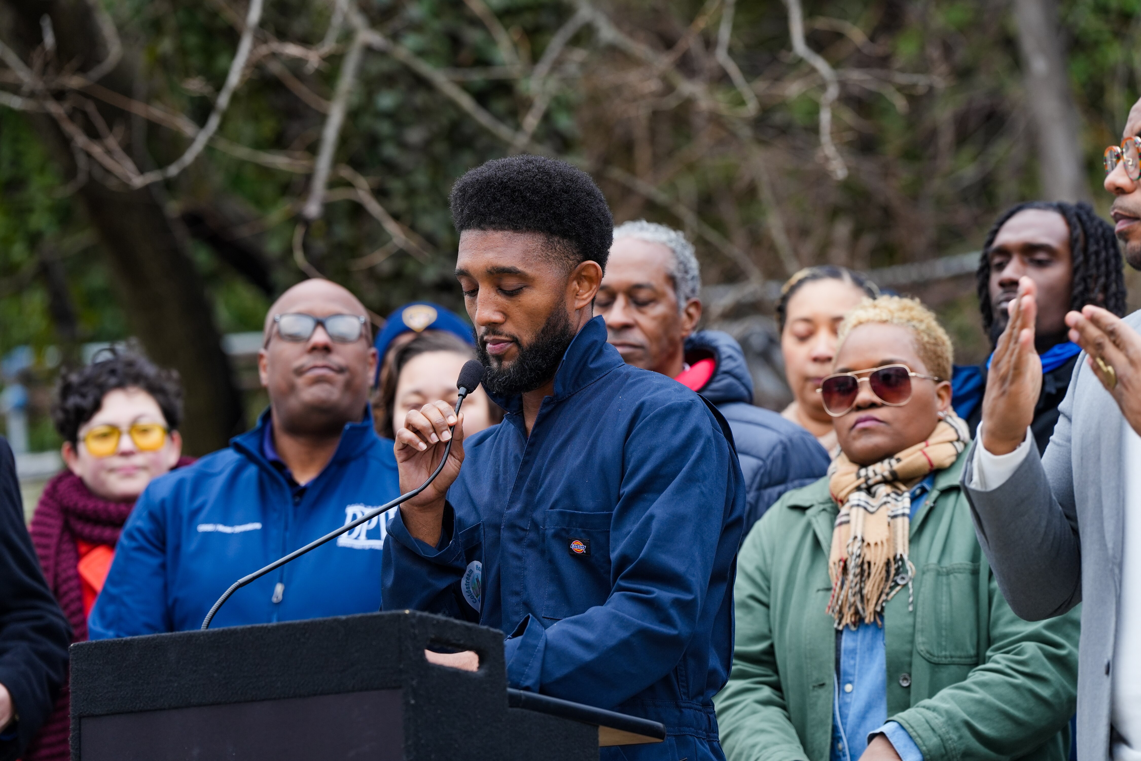 man stands at podium talking into a microphone.