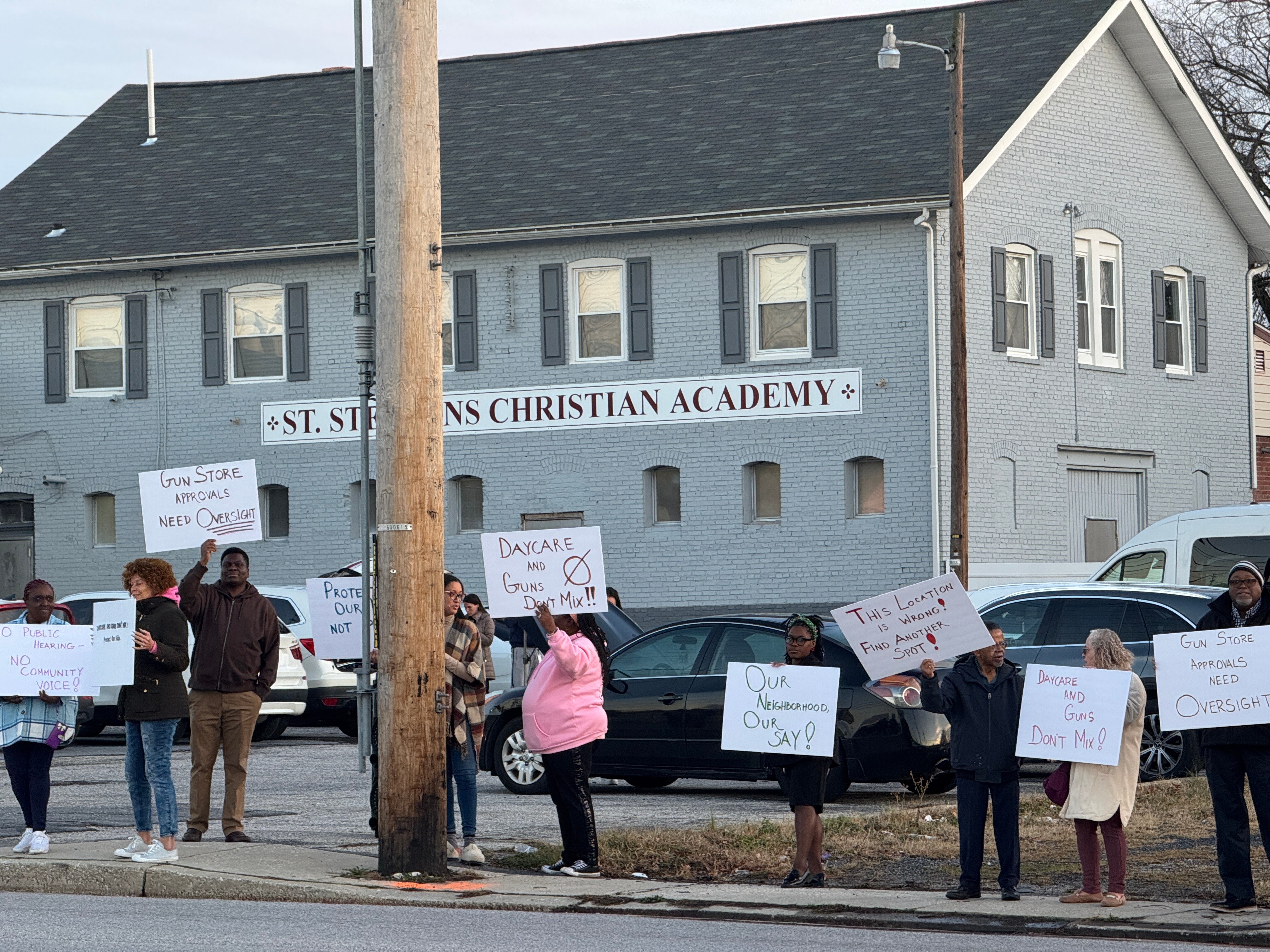 Essex residents protest a gun shop that opened across from a church, day care and school.