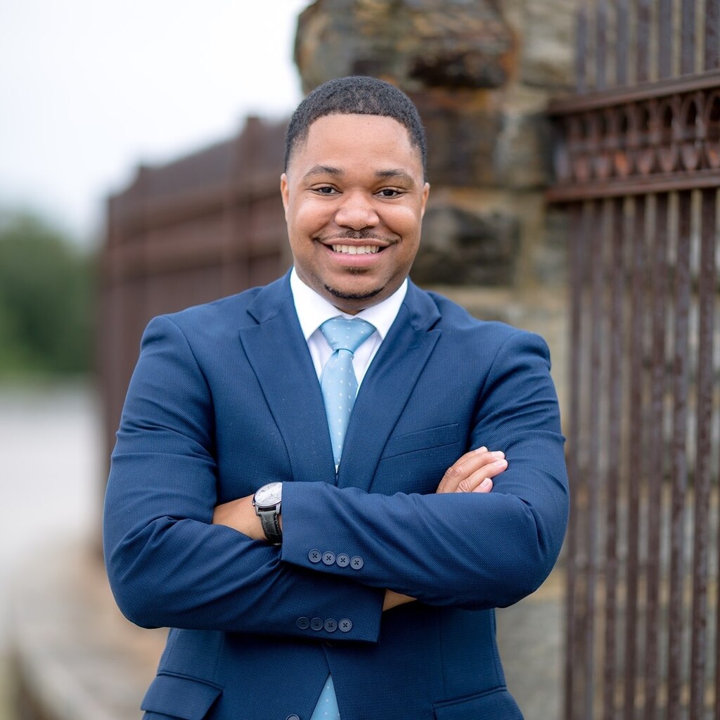 A photo of Baltimore City Councilman James Torrence in a dark blue suit wearing a light blue tie.