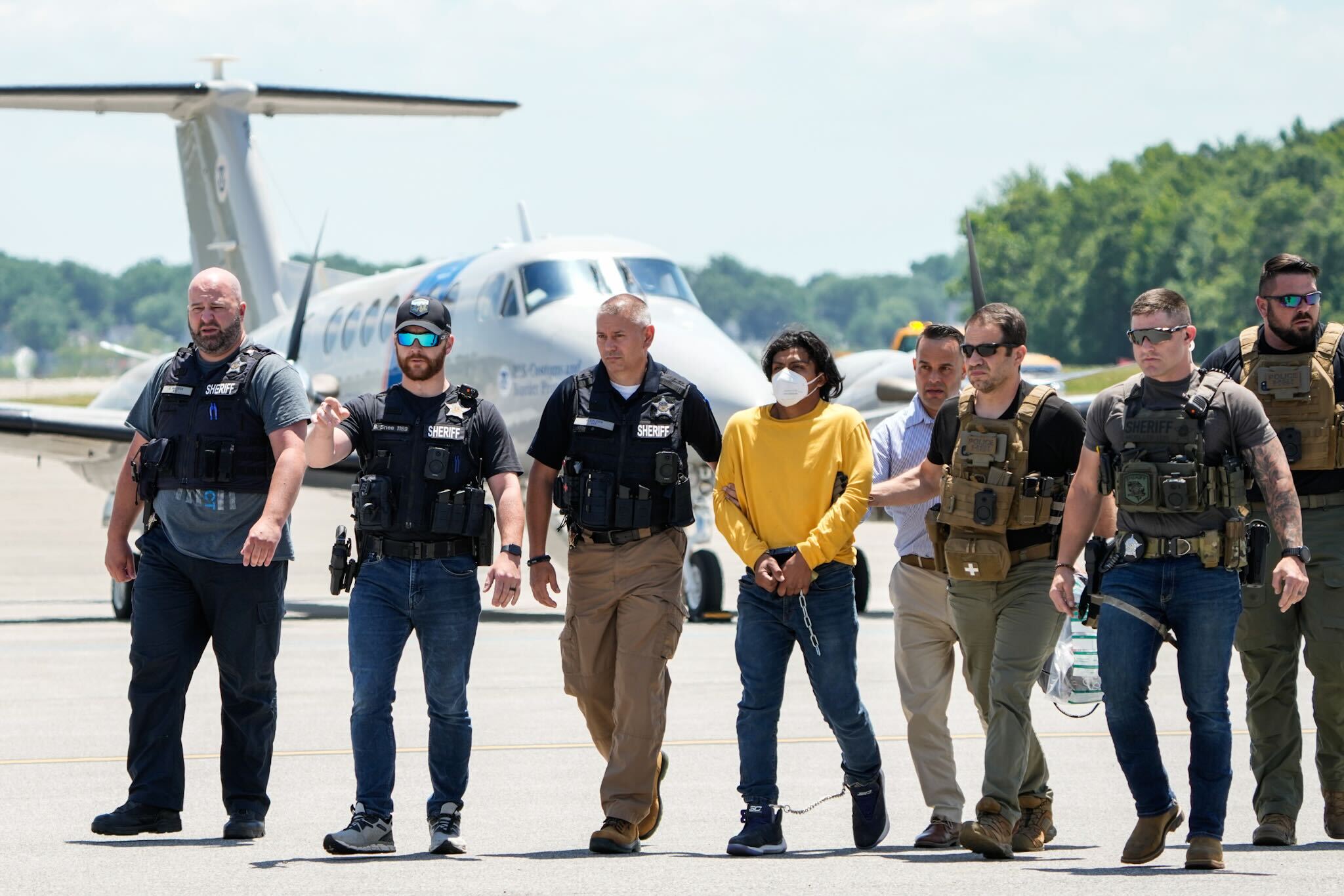 Law enforcement agents escort Victor Martinez Hernadez from an airplane at Martin State Airport after his extradition from Oklahoma, June 20, 2024.