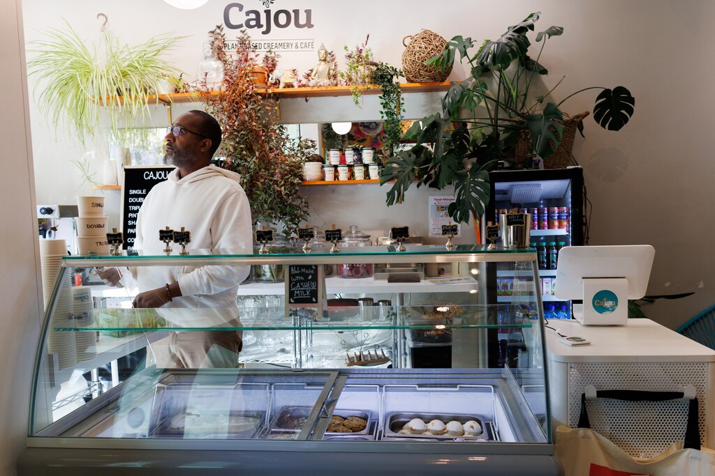 Dwight Campbell, one of the owners of Cajou Creamery, a vegan ice cream shop and cafe on Howard Avenue is one of the businesses of the Howard Avenue superblock, prepares to scoop ice cream.