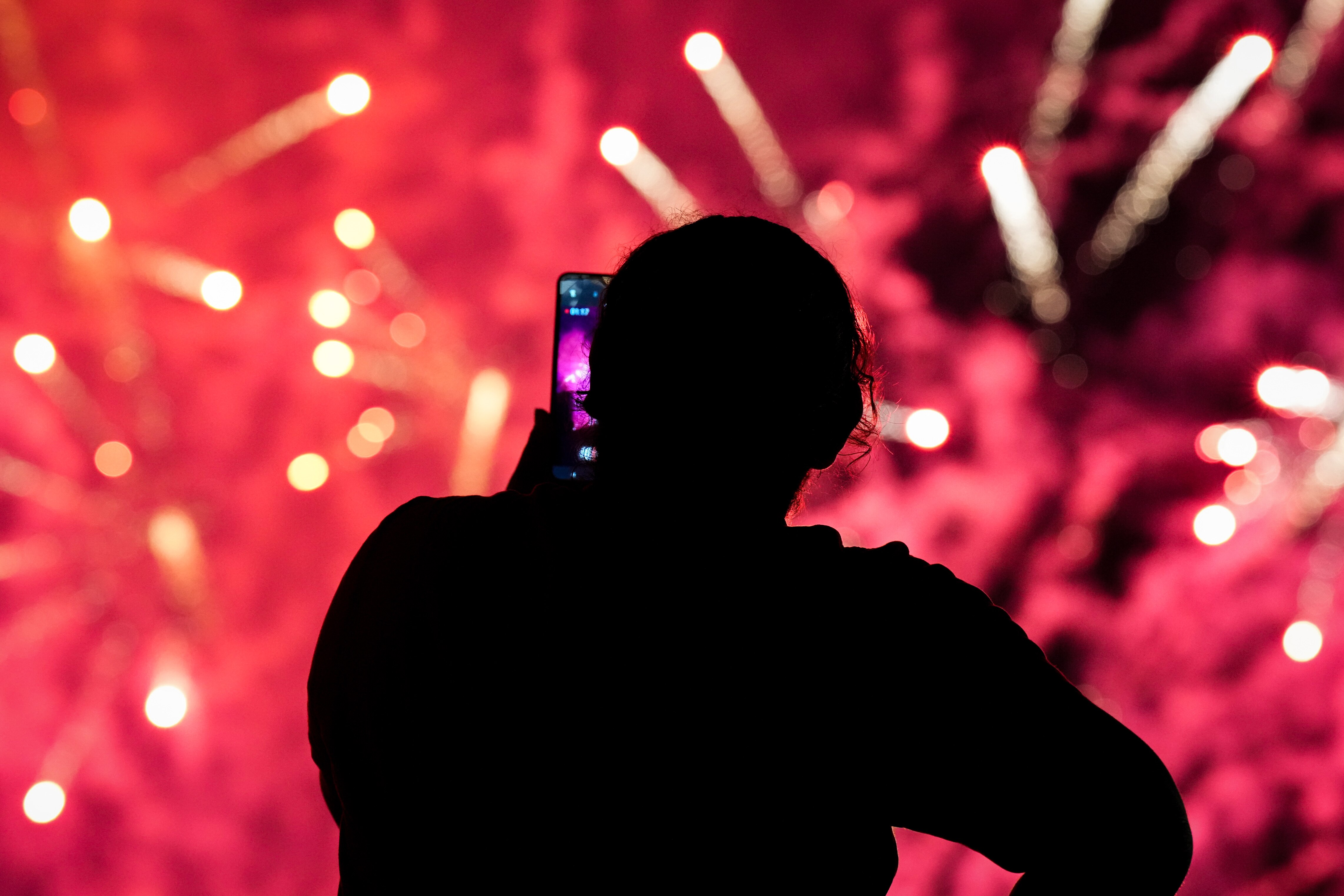 Griselda Urbina watches as fireworks go off in the Inner Harbor as Baltimore City celebrates Independence Day on July 4, 2023.