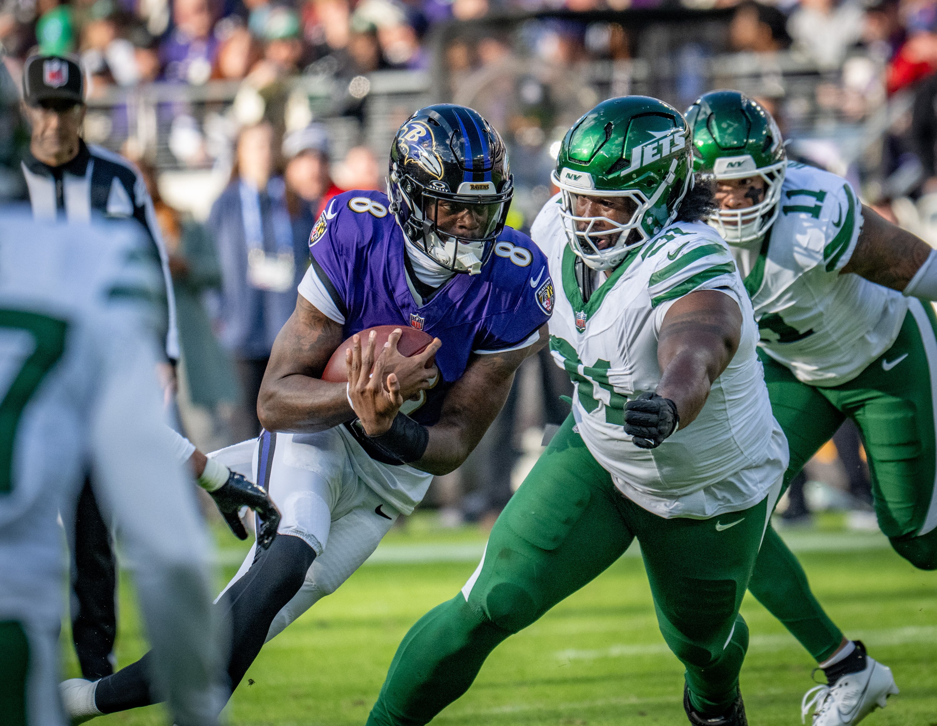 Ravens quarterback Lamar Jackson runs for a short gain under pressure in the second quarter of the team’s 23-10 win over the New York Jets.