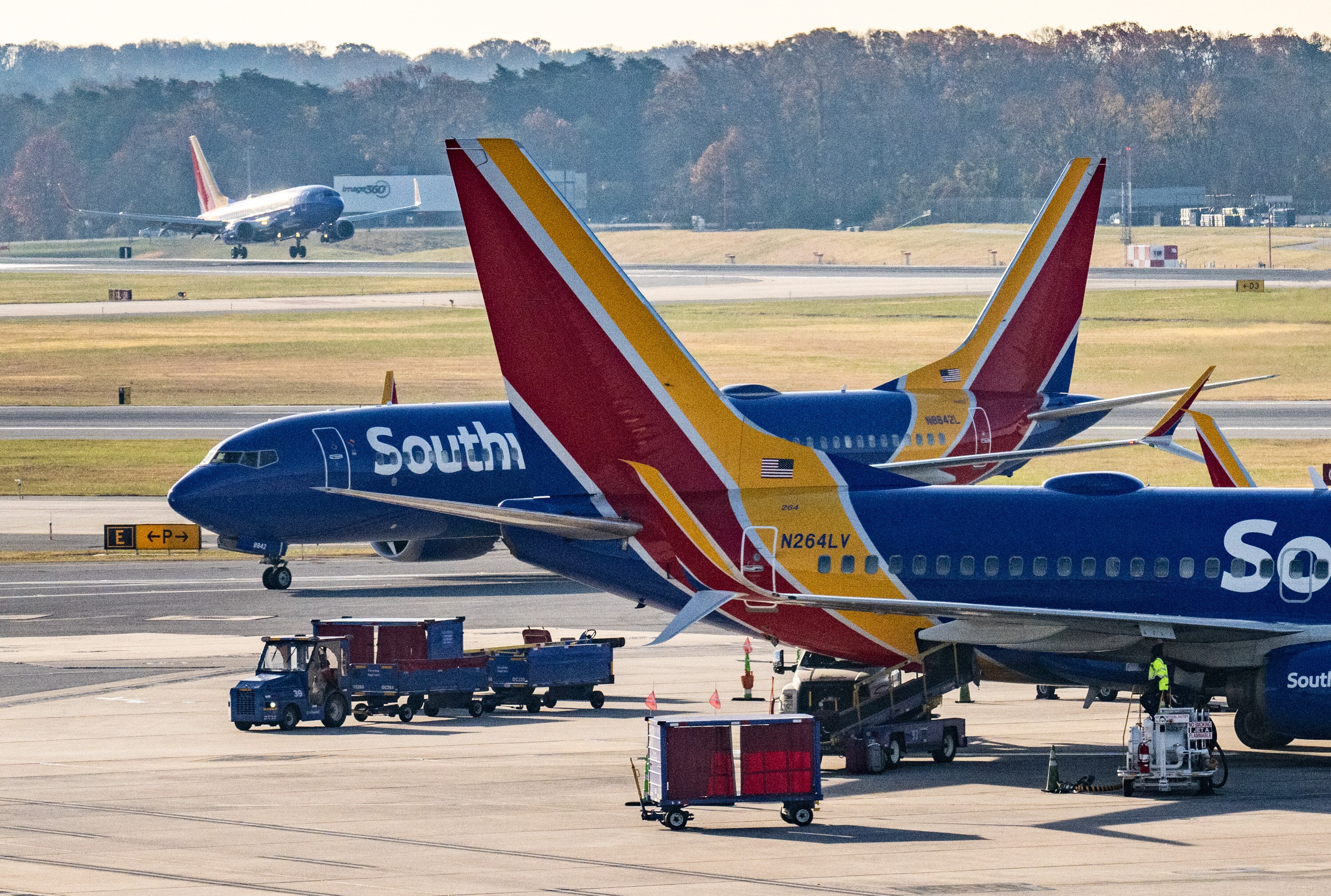 An arriving Southwest Airlines flight lands at BWI Marshall Airport as others prepare for departure at the start of the busy holiday travel week.