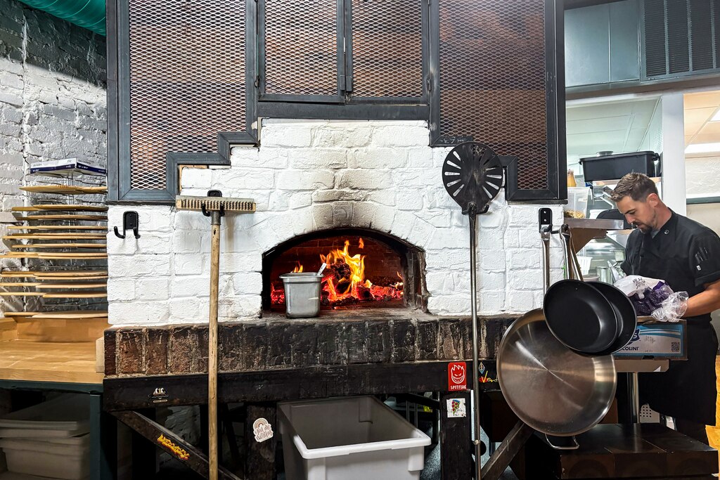 FRIDAY, AUGUST 8, 2025 - Raffy's wood-fired oven burns bright while staff prepares for their opening on Friday, August 8.