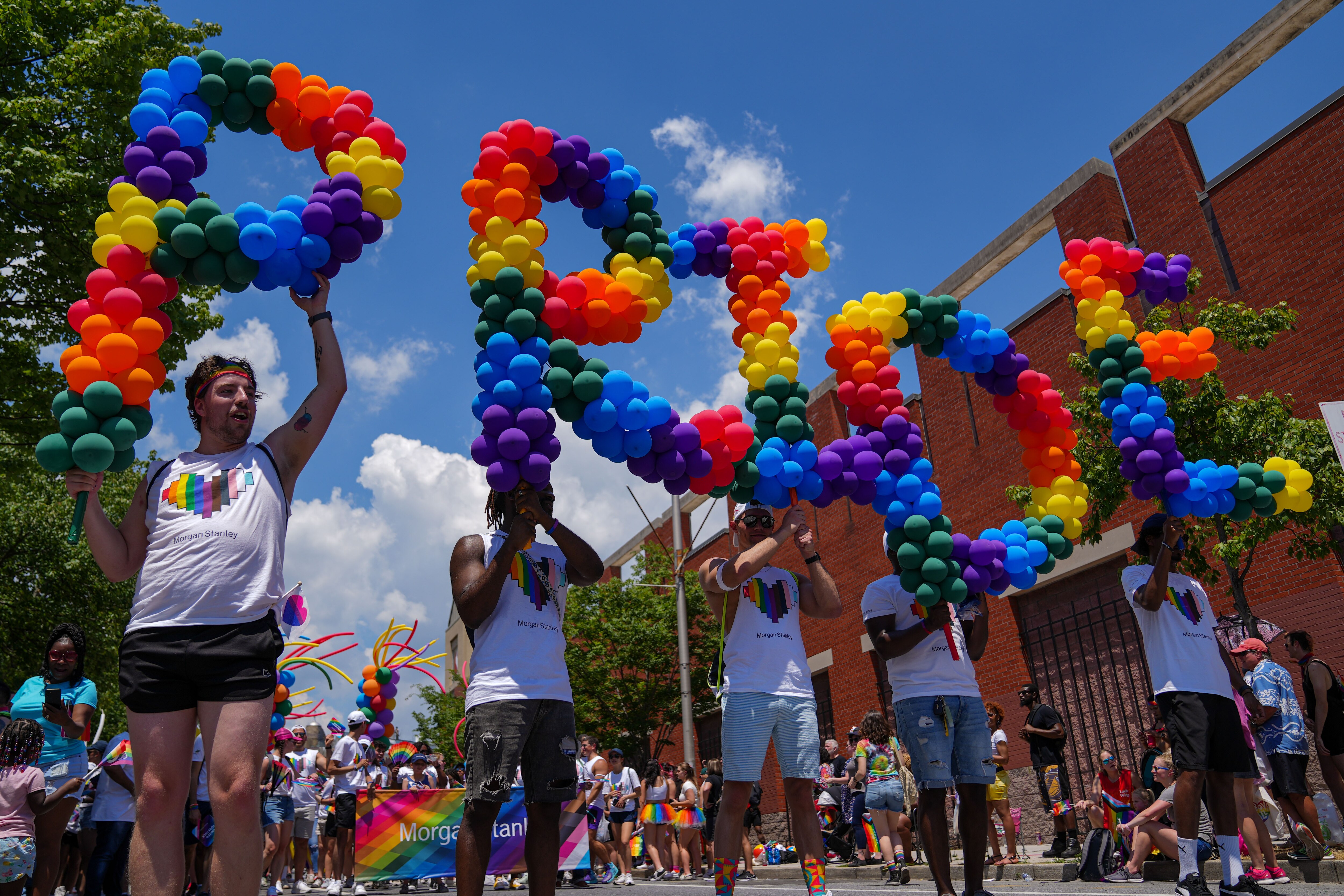 6/25/22—Marchers with Morgan Stanley hold balloons that read “PRIDE” during the Baltimore Pride Parade on Charles St.