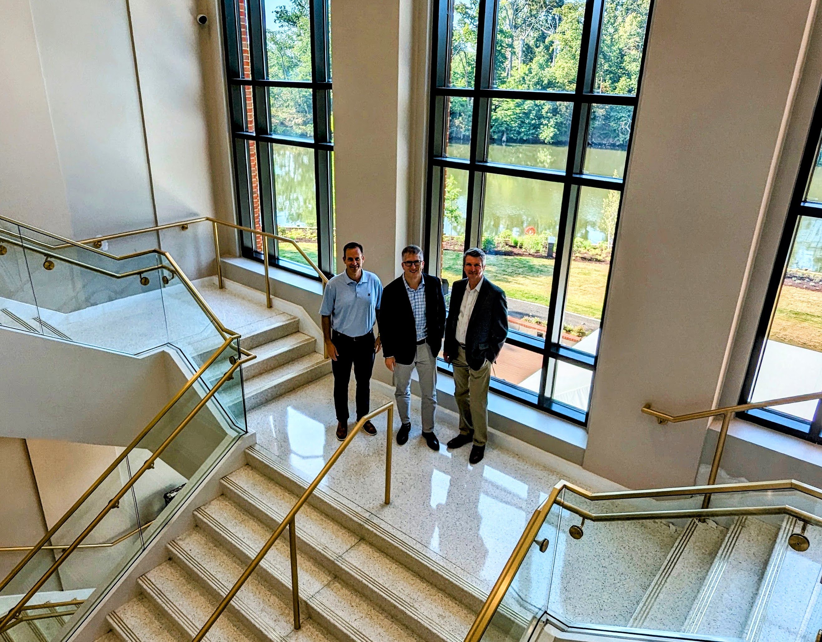 Jeff Webb, CEO of the Naval Academy Alumni Association & Foundation stands in the main stairwell of the new Fluegel Alumni Center with, left, Executive Vice Presidents Thomas Grady and, right, Bob O'Connor.