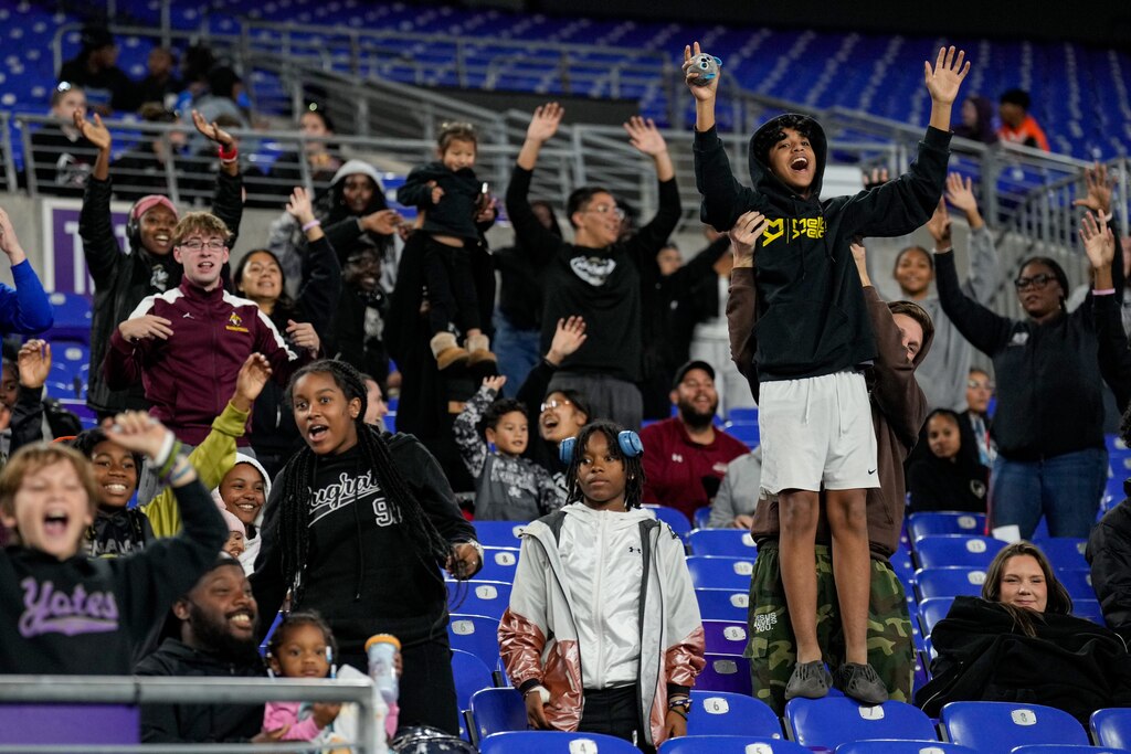 Fans raise their hands and cheer in the hopes of catching a free t-shirt during the 2024 Maryland High School Girls Flag Football Championship