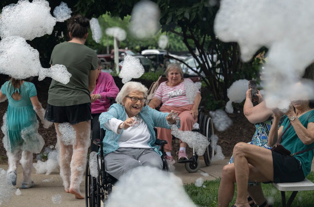 A resident at North Oaks Senior Living, the same building that the the Spark Summer Program is held at, enjoys the foam from the camp foam party on July 1, 2025.